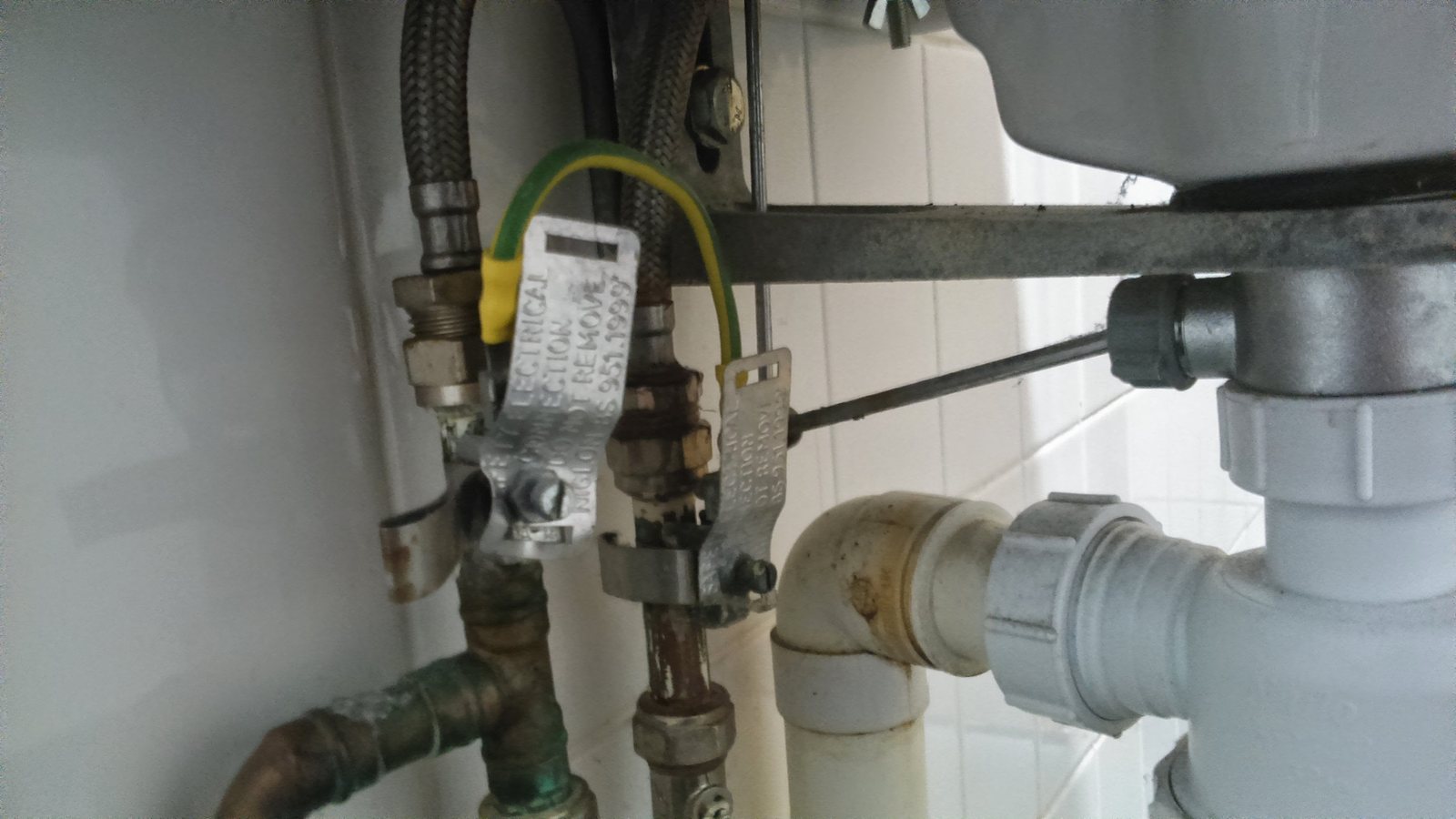 Accessible under-sink drain trap and water-supply connections